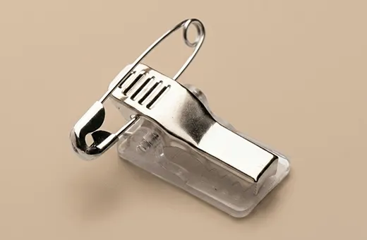 Self-adhesive combo clip with alligator clamp and safety pin sticking directly to the back of a printed badge